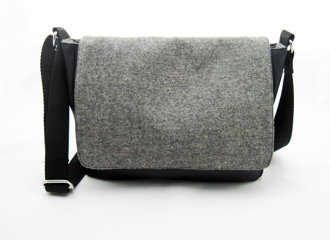 Die frontalke Ansicht einer schwarzen Messenger Tasche mit grauem Tweed-Deckel.
