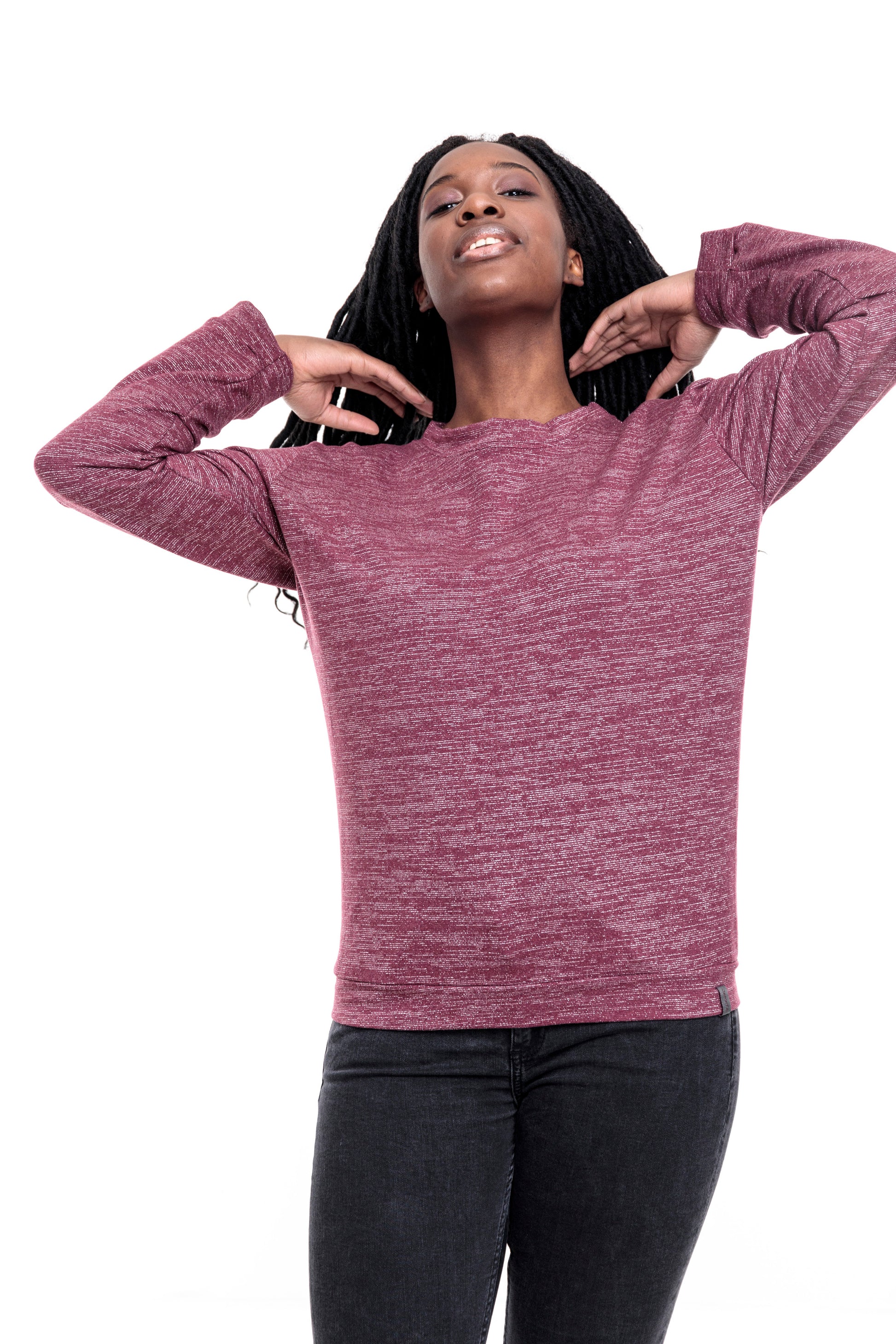 Eine junge Frau mit langen Braids. Sie trägt ein weinrotes, meliertes Sweatshirt mit silbernen Lurexfäden. Das Sweatshirt ist ca. hüftlang, hat lange Ärmel und einen Runden Halsausschnitt. Als Abschluss an den Ärmeln, dem Bund und dem Hals hat der Pulli Bündchen aus dem gleich Stoff. 
Ansicht frontal, mit hochgehobenen Armen.