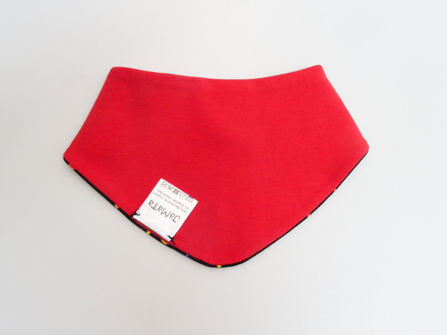 Halstuch für Babys und kleine Kinder schwarz mit buntem Schriftzug Helau, Konfetti, Luftschlangen und Regenbögen. Ansicht unifarbene, rote Seite geschlossen.