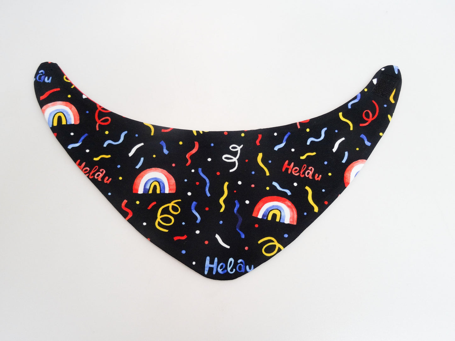 Halstuch für Babys und kleine Kinder schwarz mit buntem Schriftzug Helau, Konfetti, Luftschlangen und Regenbögen. Ansicht bunte Seite aufgeklappt.