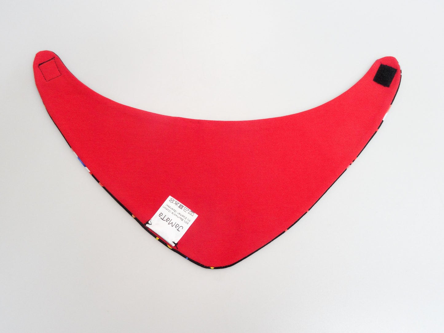 Halstuch für Babys und kleine Kinder schwarz mit buntem Schriftzug Helau, Konfetti, Luftschlangen und Regenbögen. Ansicht unifarbene, rote Seite aufgeklappt.