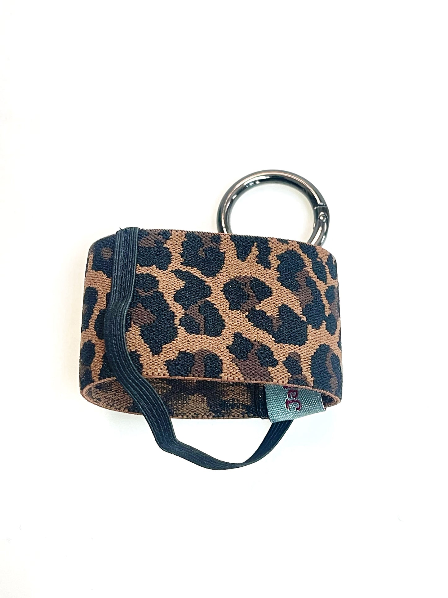 Der Becherhalter mit Leoparden Muster flach hingelegt. Man sieht, dass das schmale, schwarze Gummiband unten um den Halter herum geht.