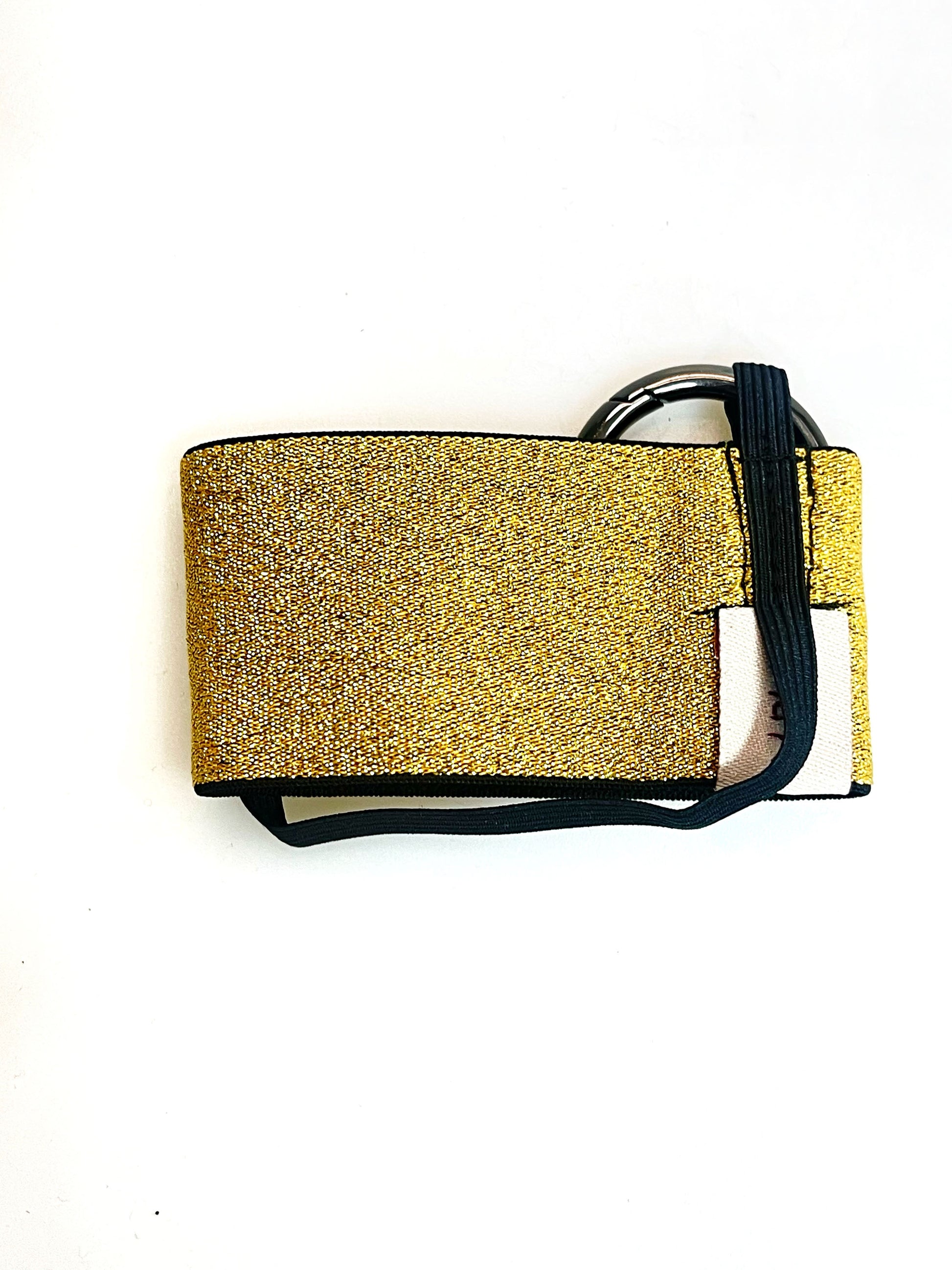 Der goldene Becherhalter flach hingelegt. Man sieht, dass das schmale, schwarze Gummiband unten um den Halter herum geht.