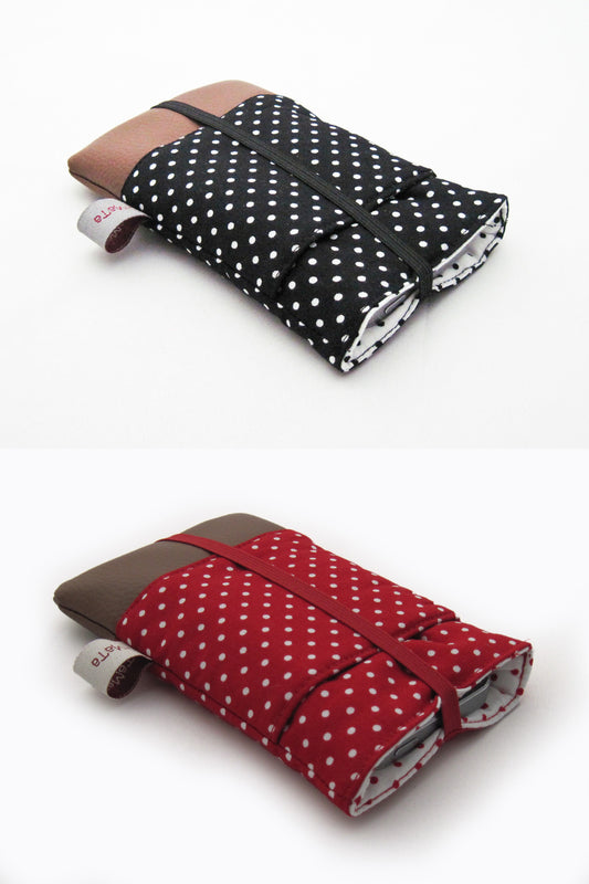 2 Handytaschen, eine aus schwarzer Baumwolle mit weißen Pünktchen oden und braunem Kunstleder unten. Die andere aus roter Baumwolle mit weißen Pünktchen oden und braunem Kunstleder unten. Beide haben eine  aufgesetzte Tasche und sind mit farblich passendem Gummiband verschlossen.