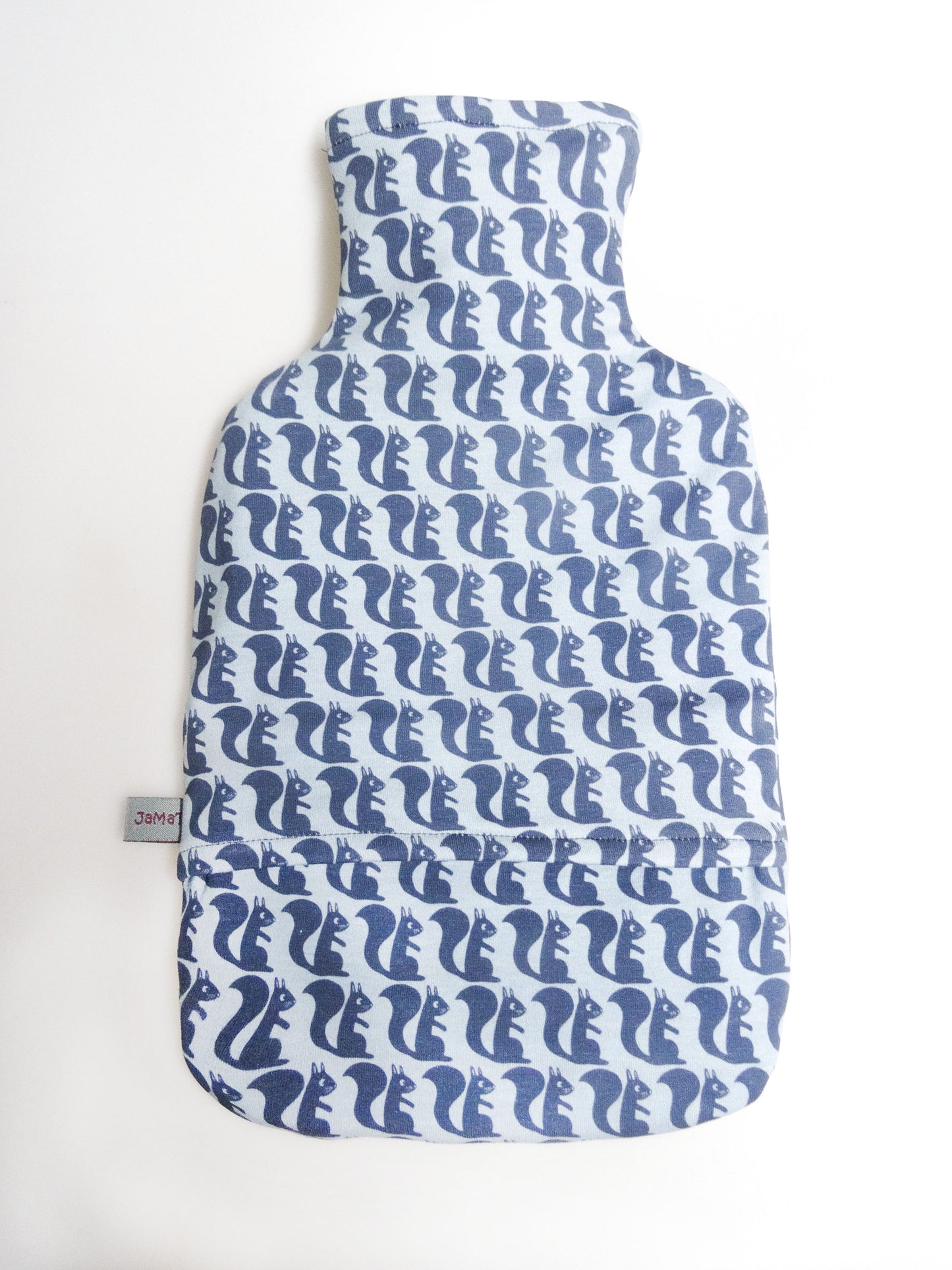Das Rückteil der Wärmflasche mit den blauen, gezeichneten Eichhörnchen senkrecht von oben fotografiert. Man sieht die Öffnung, in die man die Gummiwärmflasche stecken kann.