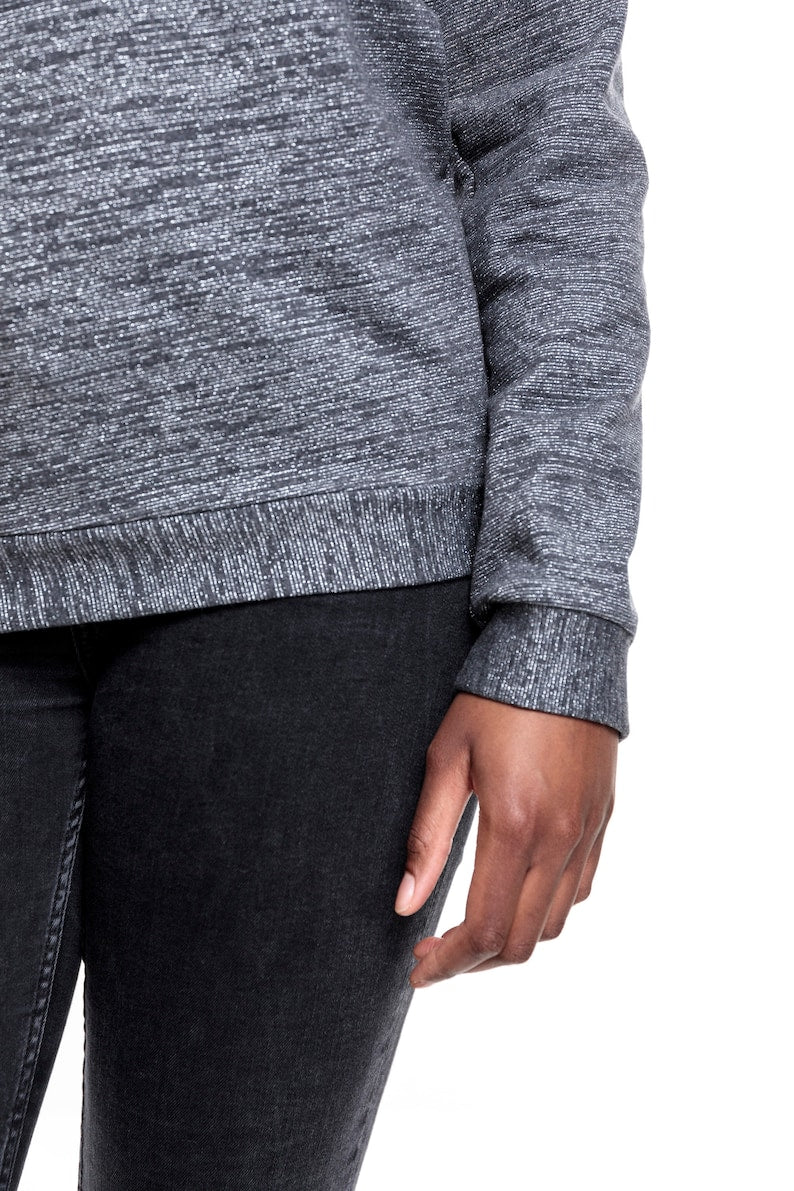 Detailansicht vom Saum und einem Ärmelsaum. Man sieht die Bäündchen aus dem gleich Stoff.