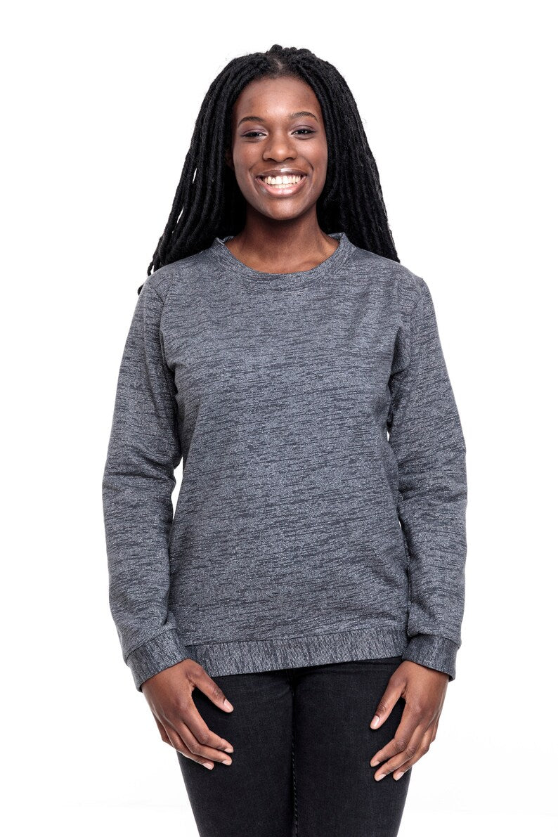 Eine junge Frau mit langen Braids. Sie trägt ein graues, meliertes Sweatshirt mit silbernen Lurexfäden. Das Sweatshirt ist ca. hüftlang, hat lange Ärmel und einen Runden Halsausschnitt. Als Abschluss an den Ärmeln, dem Bund und dem Hals hat der Pulli Bündchen aus dem gleich Stoff. 
Ansicht frontal.