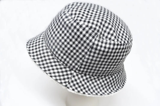 Der Fischerhut mit der schwarz-weißen Pepita seite außen vor einem weißen Hintergrund