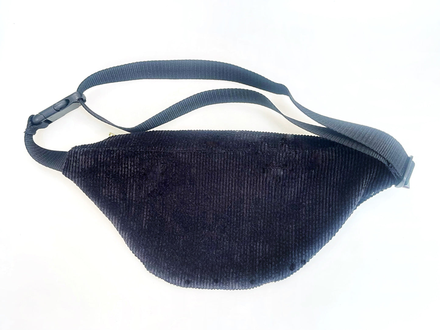 Die Rückansicht der Bauchtasche. Man sieht, dass das komplette Rückteil und der Deckel aus schwarzem Breitcord sind. 
