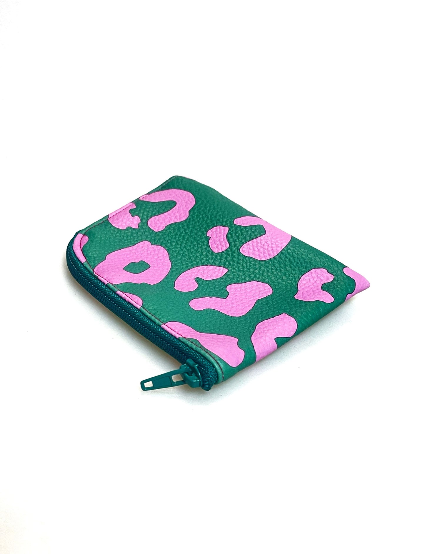 Kleine Geldbörse aus grünem Kunstleder mit pinken Leopradenflecken. Sie ist rechteckig mit einer abgerundeten Ecke. An zwei Seiten ist sie mit einem grünen Reißverschluss geschlossen. Ansicht von schräg oben. 