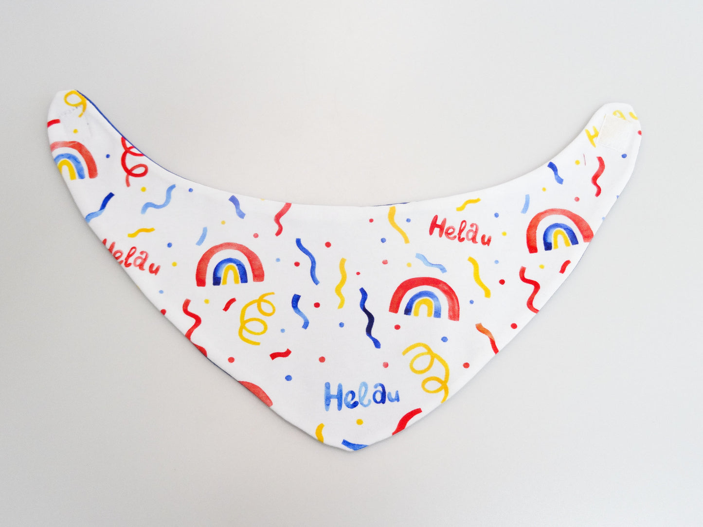 Halstuch für Babys und kleine Kinder weiss mit buntem Schriftzug Helau, Konfetti, Luftschlangen und Regenbögen. Ansicht bunte Seite aufgeklappt.  