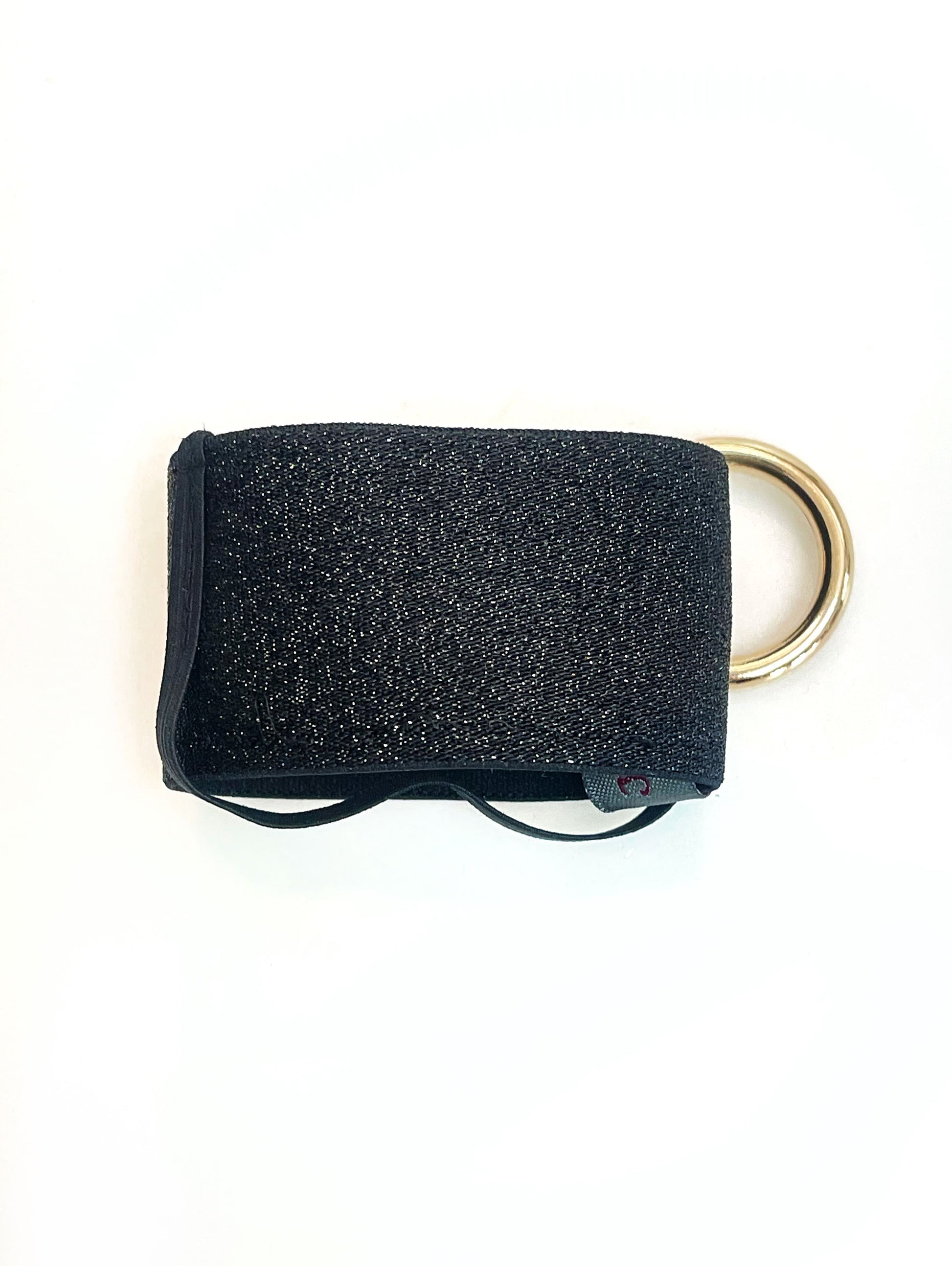 Der schwarze Becherhalter flach hingelegt. Man sieht, dass das schmale, schwarze Gummiband unten um den Halter herum geht. 